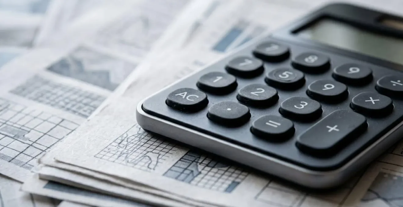 Close-up view of financial planning materials including calculator and organized paperwork illustrating medical loan assessment process